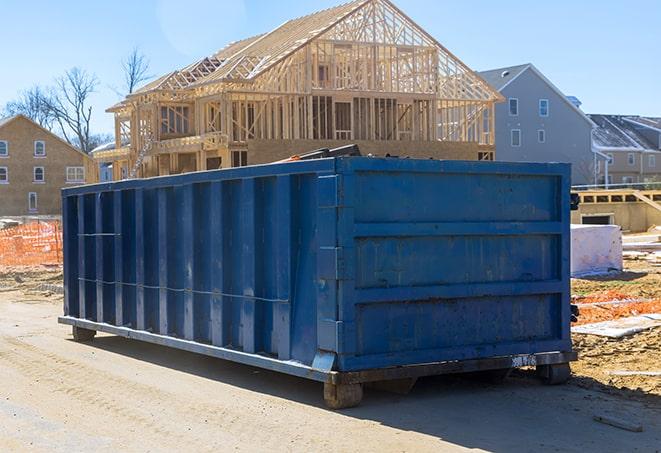 a row of residential dumpsters parked on a street corner